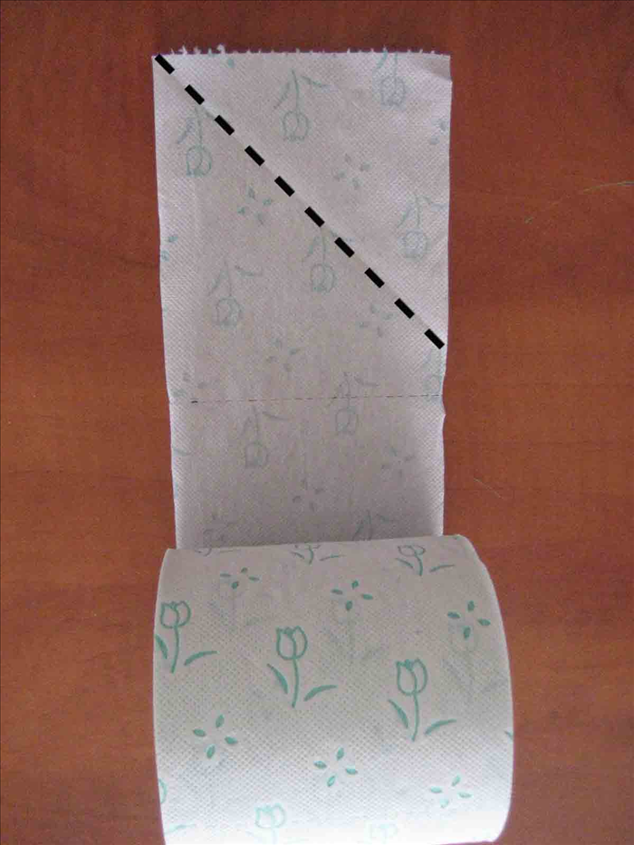 משכו בגליל הנייר טואלט עד שיצאו מספר ריבועי נייר (לא לחתוך). קפלו את הפינה הימנית כלפי מטה עד הדופן השמאלי - יווצר משולש.