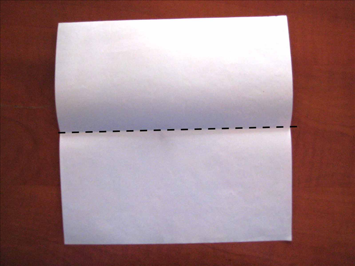 הניחו את הנייר כאשר החלק אותו תרצו שיהיה על המסגרת יהיה עם הפנים כלפי מטה.
קפלו לחצי בצורה מאוזנת ופתחו את הקיפול.