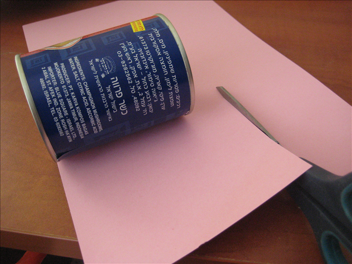 חתכו את הנייר 4 ס'מ גבוה יותר מהגובה של 2 הפחיות ומספיק ארוך בכדי שאפשר יהיה ללפף אותן.
