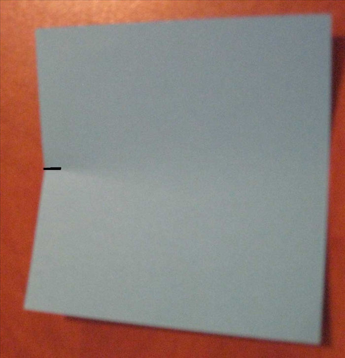 קפלו ריבוע הנייר לחצי אך 'צבטו' את הקיפול רק כדי לסמן את מרכז הנייר.