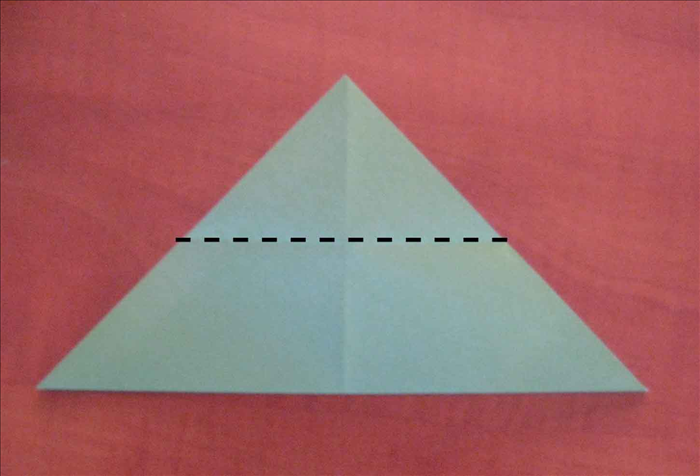 סובבו את הנייר כך שהקודקוד המרכזי יופנה כלפי מעלה.
קפלו את החלק העליון כלפי מטה עד שיגיע לקצה הנייר.