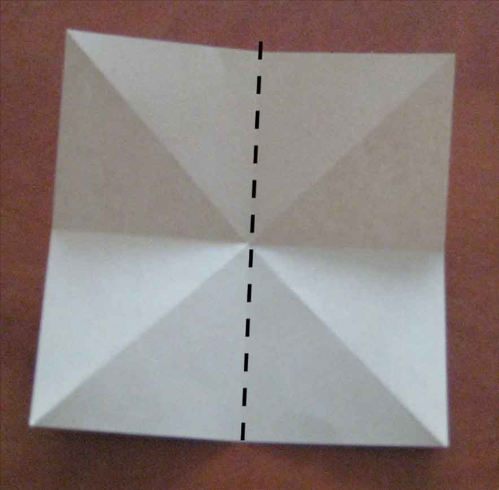 קפלו את הנייר לחצי לאורכו ופתחו את הקיפול.