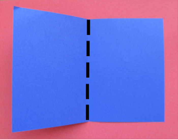 קפלו את פיסת הנייר הכחולה בגודל 23 ס'מ על 17 ס'מ לחצי.