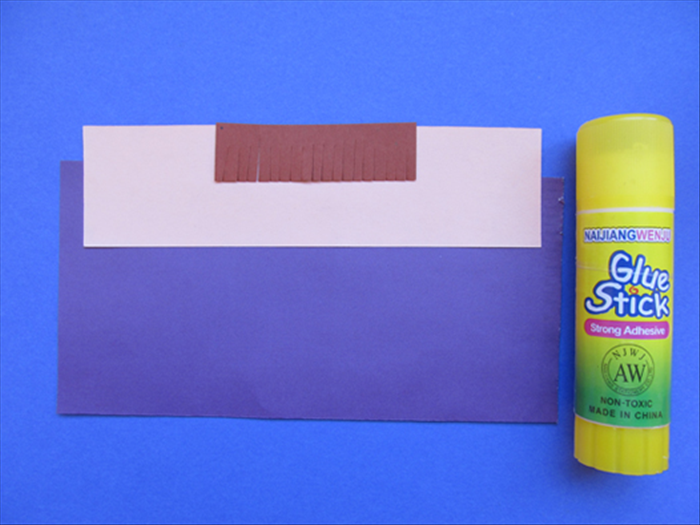 הדביקו את הנייר של הפוני כך שיהיה מיושר באמצע הדופן העליון של הנייר בצבע גוף.