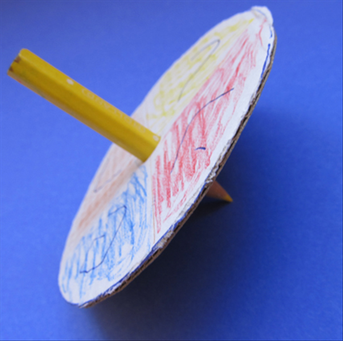 החדירו את קצה העפרון לתוך מרכז הצד הצבעוני של עיגול הקרטון.