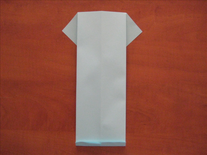 הפכו את הנייר.
קפלו מהחלק התחתון קפל קטן ( ישמש כצווארון)
כאשר משתמשים בA4, גודל הקיפול הוא כ1.5 סנטימטר - אם ברשותכם נייר שונה, שימרו על אותה הפרופורציה.